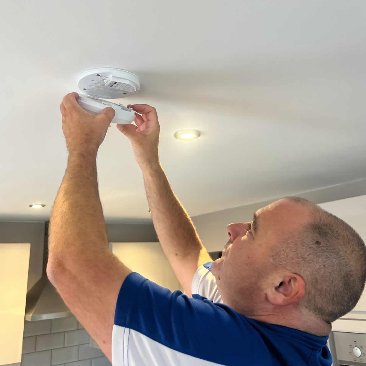 Smoke alarm being installed on a ceiling in Bath
